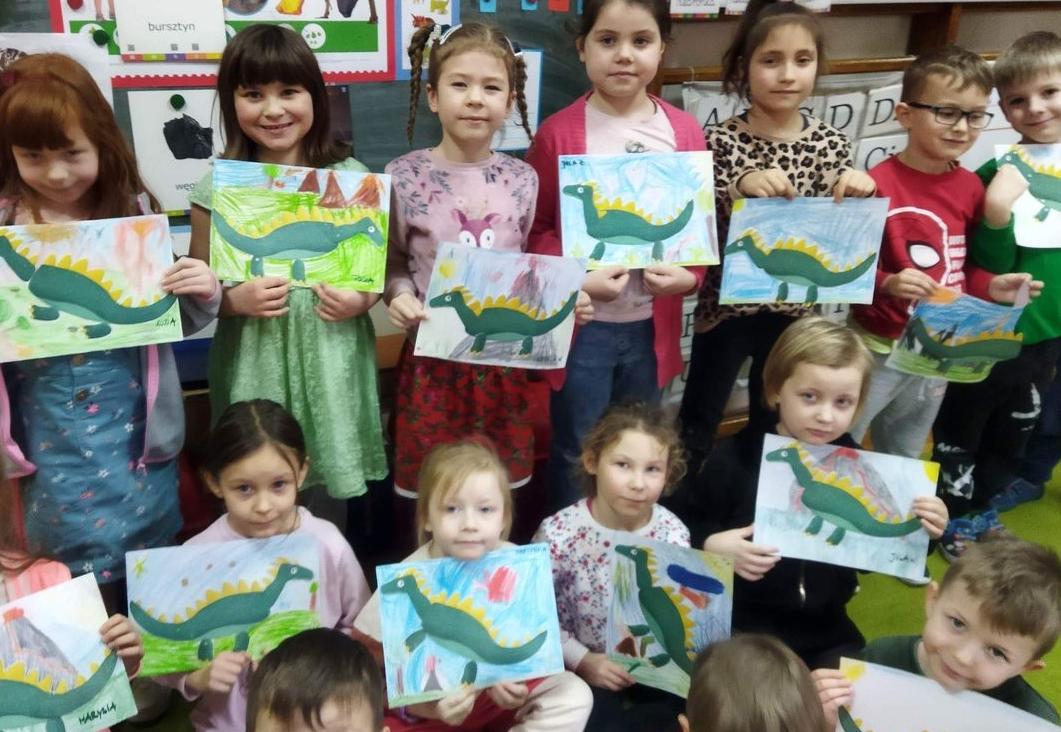 dzieci z pracami dinozaurów